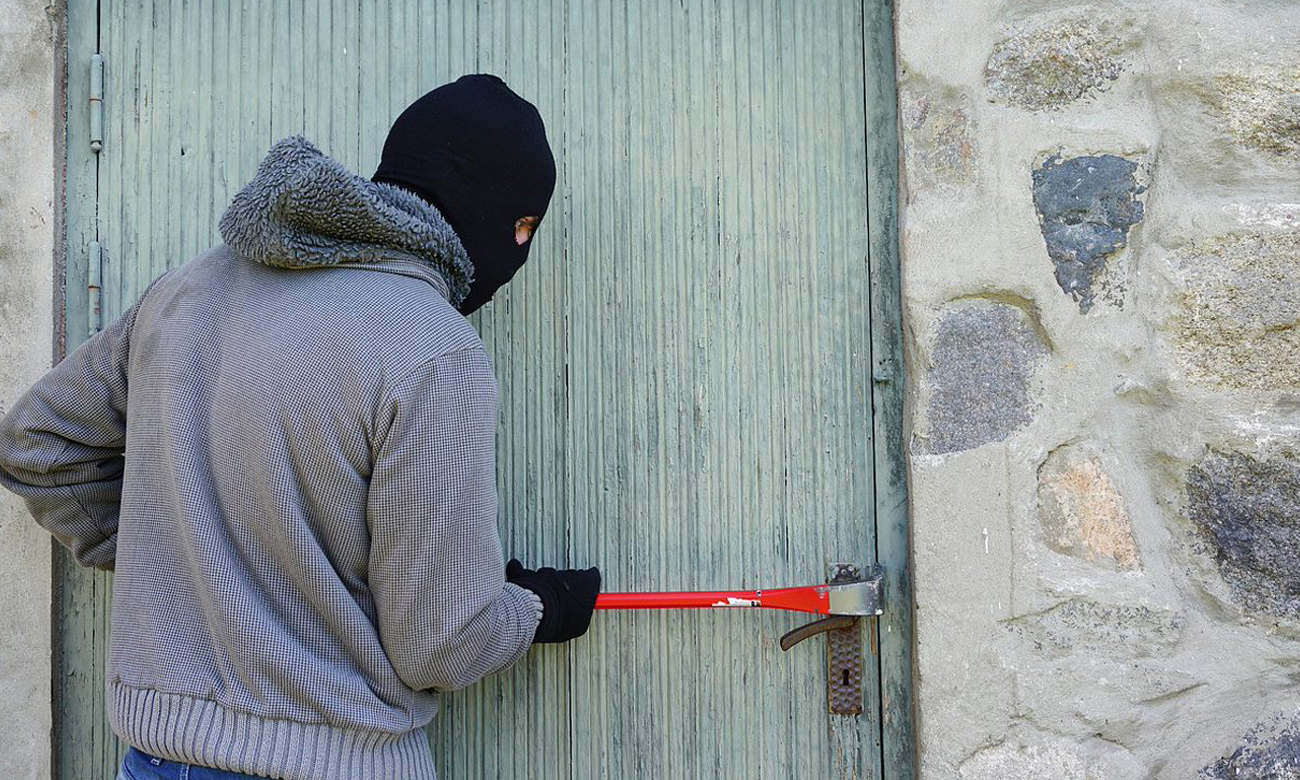 Włamywacz w kominiarce włamujący się do domu